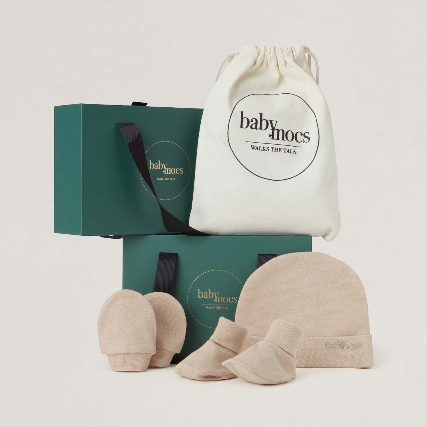 BabyMocs beige newborn set med mössa, vantar och sock mocs i mjuk bomull. Levereras i presentförpackning.